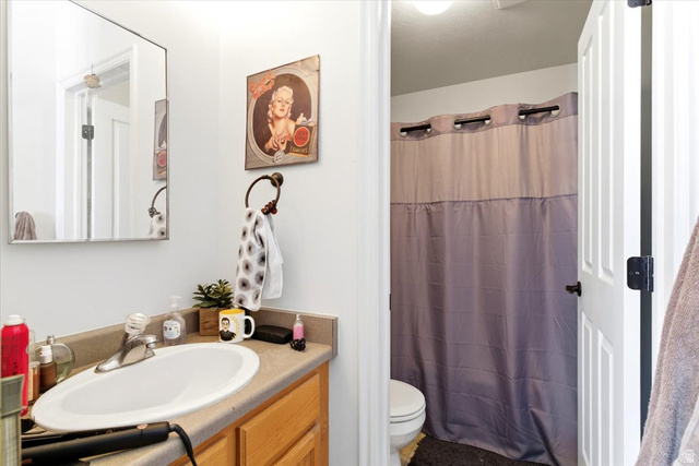 161 25th Street, Unit 6B Ogden, UT 84401 - Photo 12 of 20 Bathroom featuring a vanity with an integrated sink, a large mirror, and a wood-finish cabinet