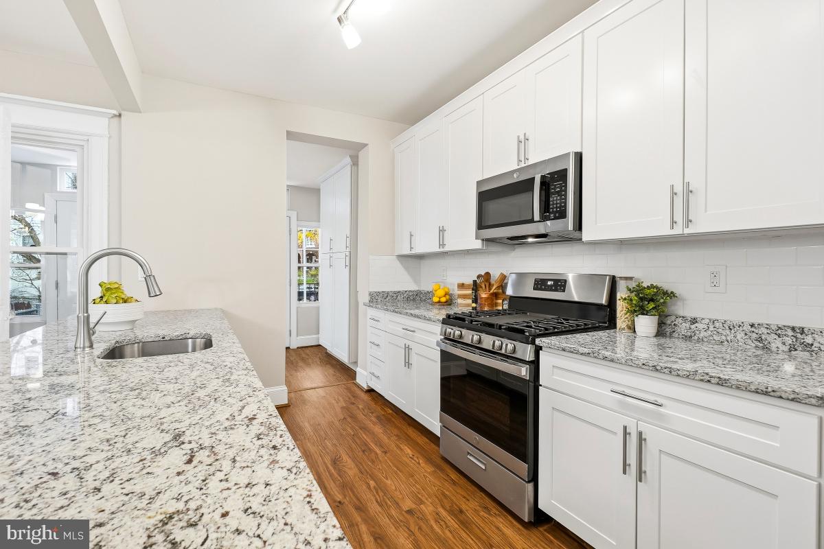 1526 Spring Place Northwest Washington, DC 20010 - Photo 13 of 35 a kitchen with granite countertop a sink stainless steel appliances and cabinets