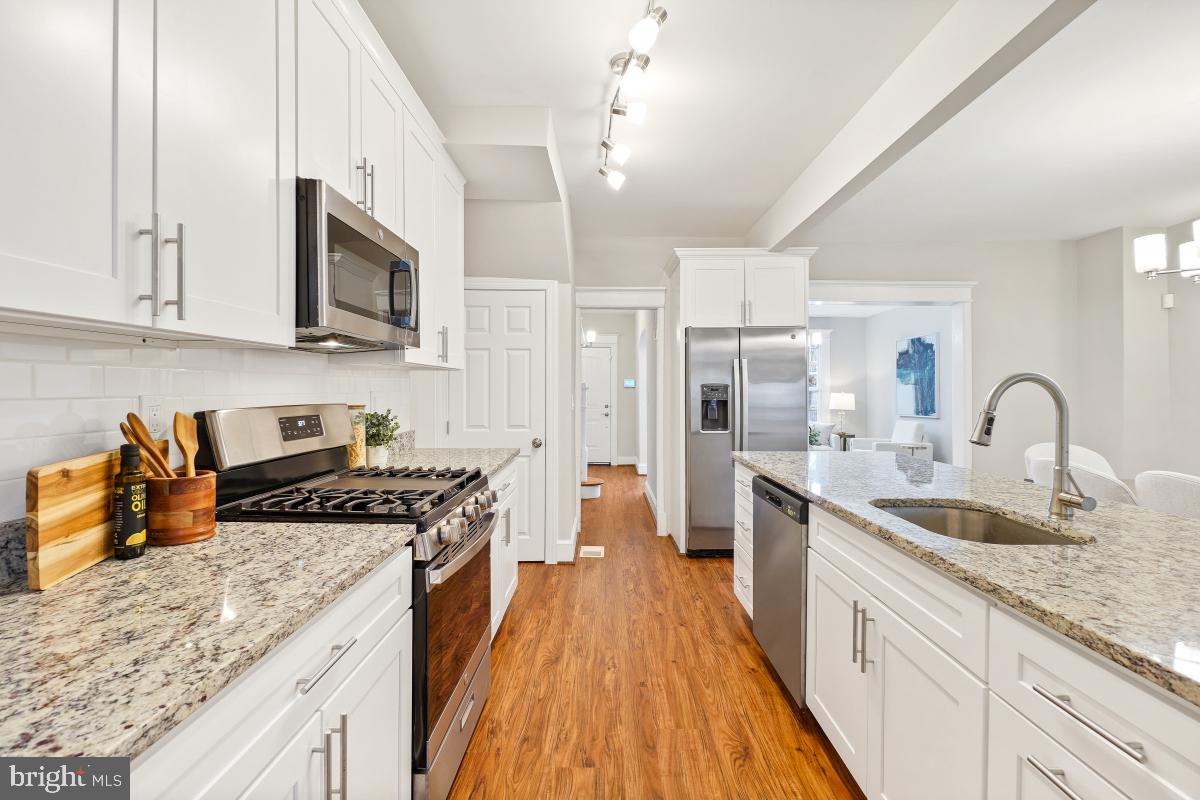 1526 Spring Place Northwest Washington, DC 20010 - Photo 14 of 35 a kitchen with stainless steel appliances granite countertop a lot of counter space and wooden floors