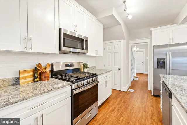 a kitchen with stainless steel appliances granite countertop a stove a sink and a refrigerator