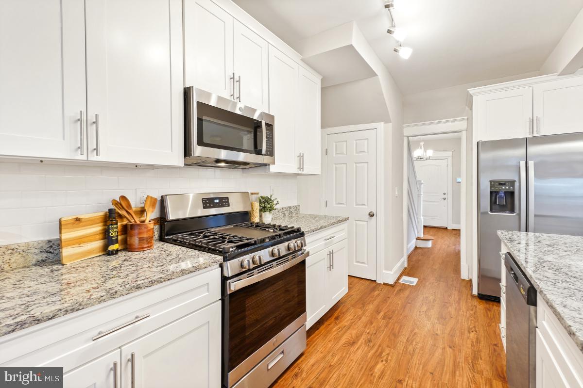 1526 Spring Place Northwest Washington, DC 20010 - Photo 15 of 35 a kitchen with stainless steel appliances granite countertop a stove a sink and a refrigerator