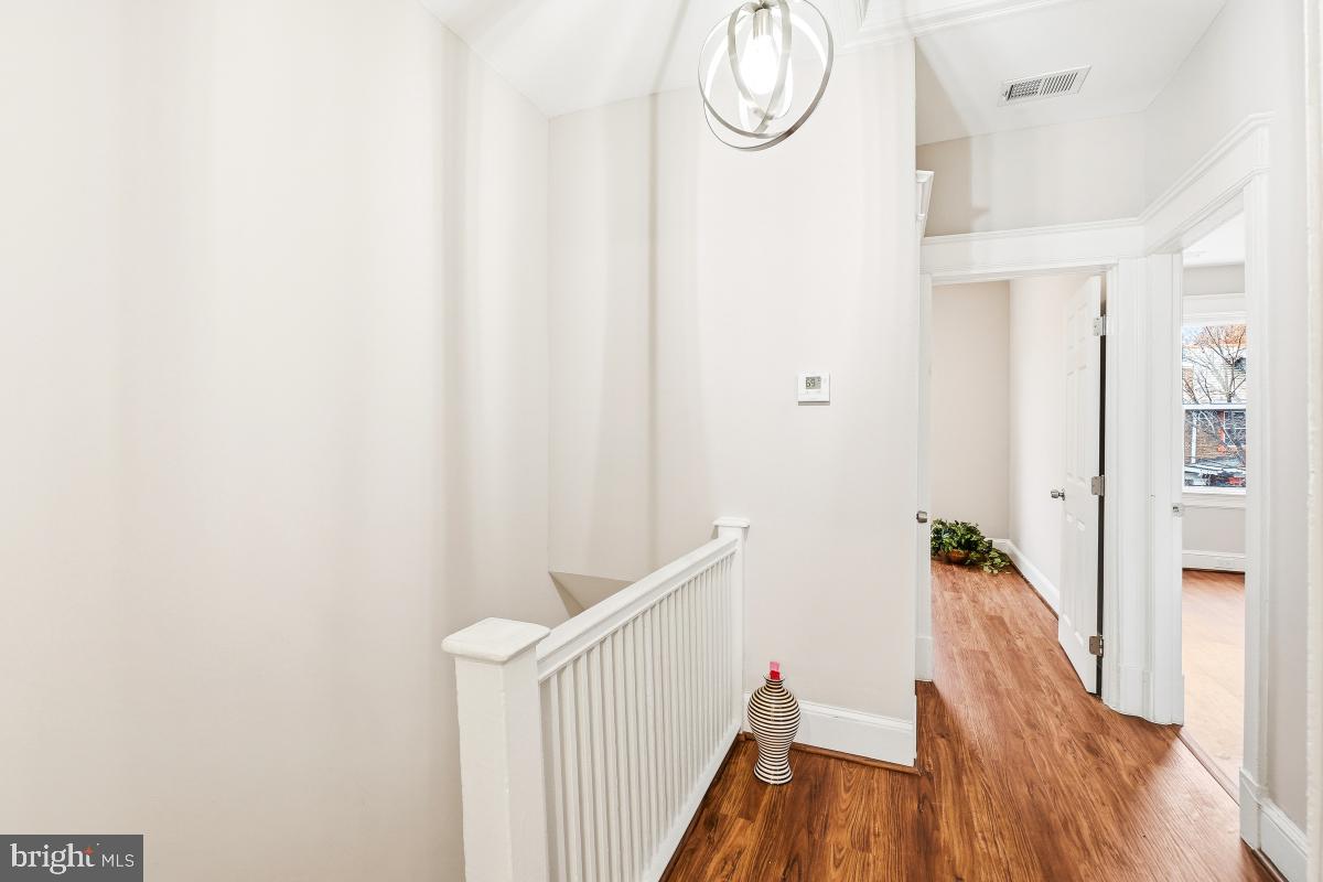 1526 Spring Place Northwest Washington, DC 20010 - Photo 18 of 35 a view of a hallway with wooden floor and staircase