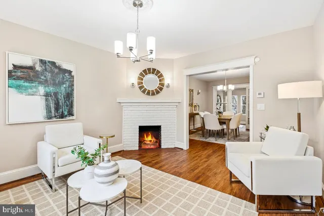 a living room with furniture a chandelier and a fireplace