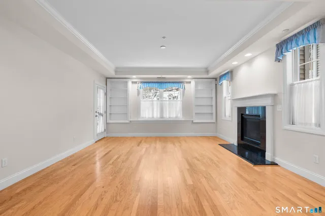 a view of an empty room with a fireplace and a window