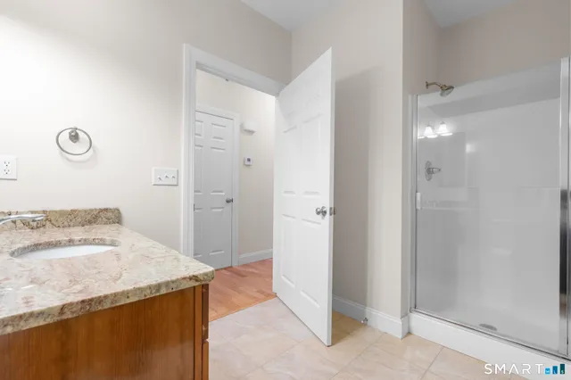 a bathroom with a granite countertop sink and a mirror