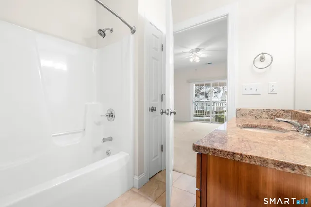 a bathroom with a granite countertop sink a bathtub and shower