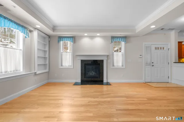 a view of an empty room with window and fire place