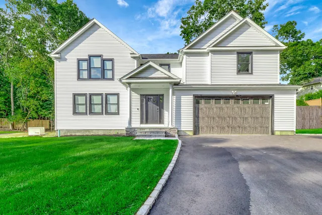 a front view of a house with a yard and garage