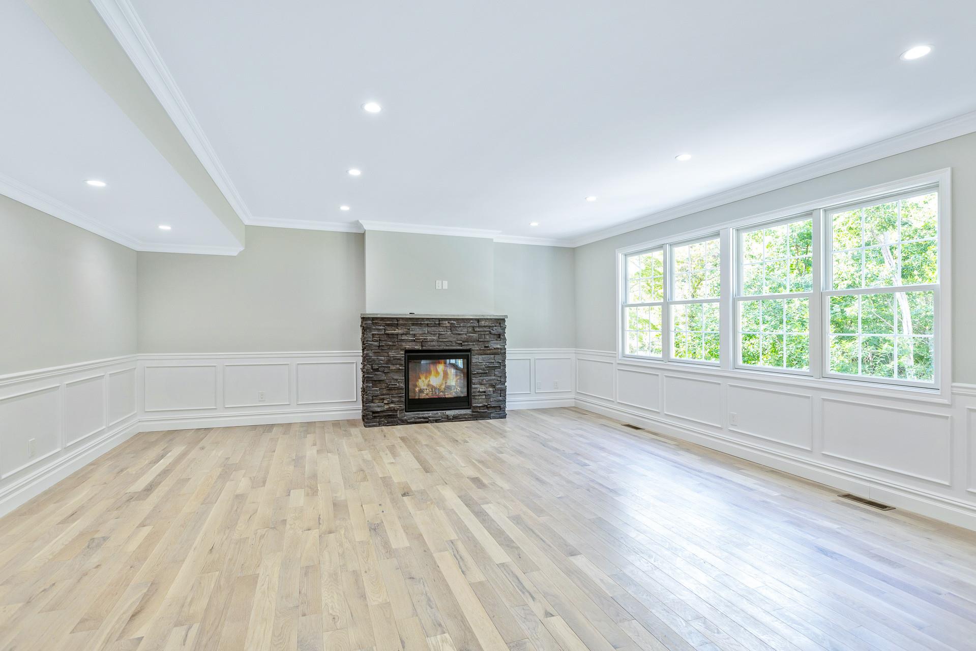 223 Town Line Road Commack, NY 11731 - Photo 12 of 32 a view of empty room with wooden floor and fireplace