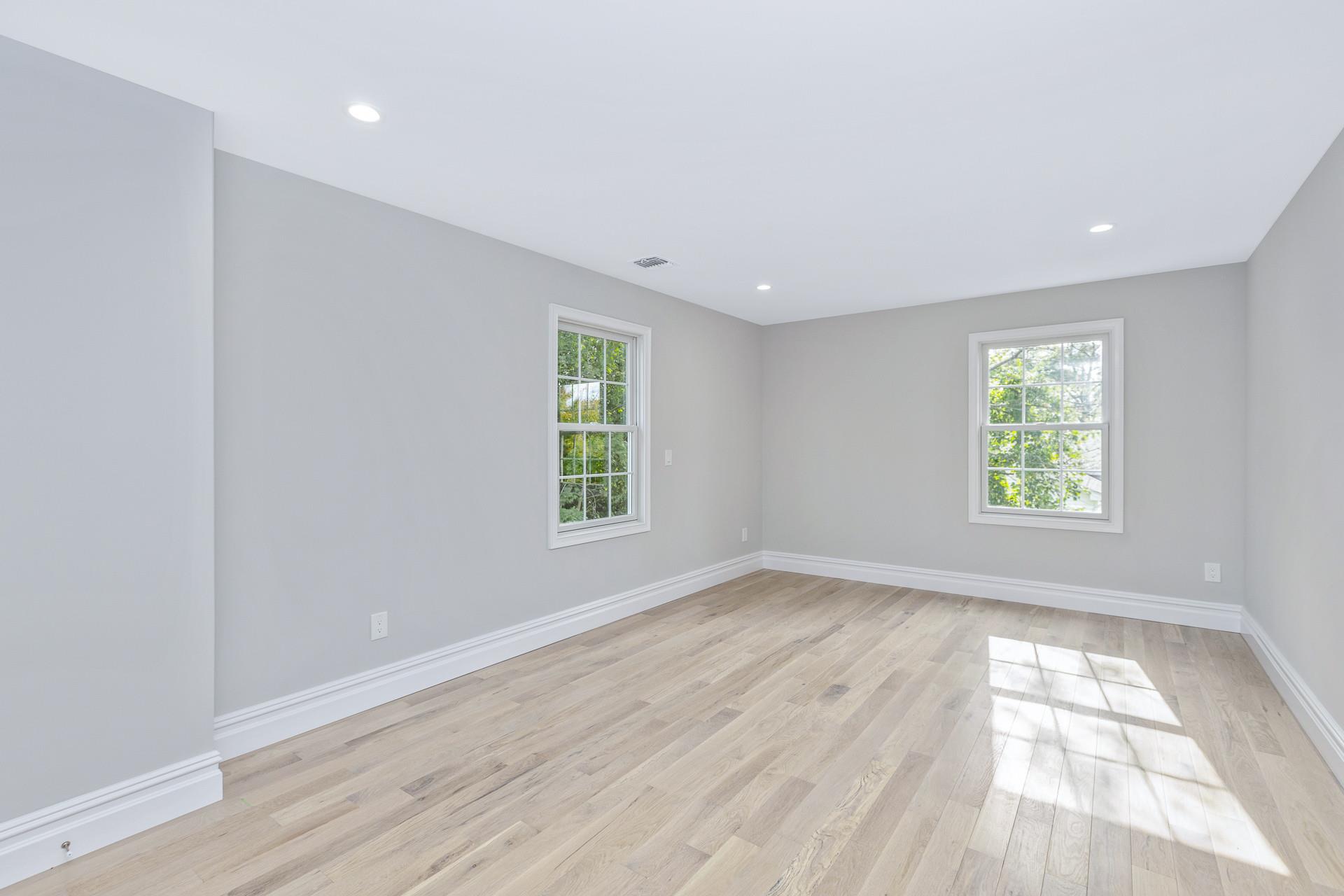 223 Town Line Road Commack, NY 11731 - Photo 14 of 32 an empty room with wooden floor and windows