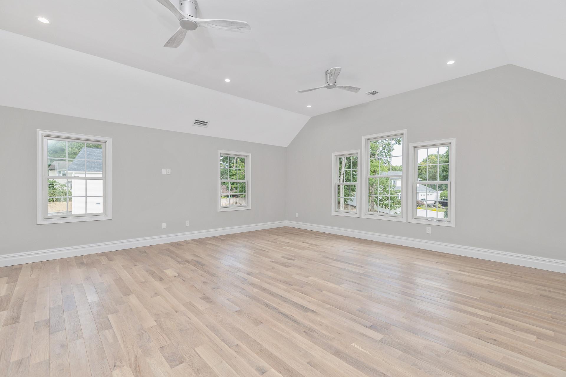 223 Town Line Road Commack, NY 11731 - Photo 19 of 32 an empty room with wooden floor and windows