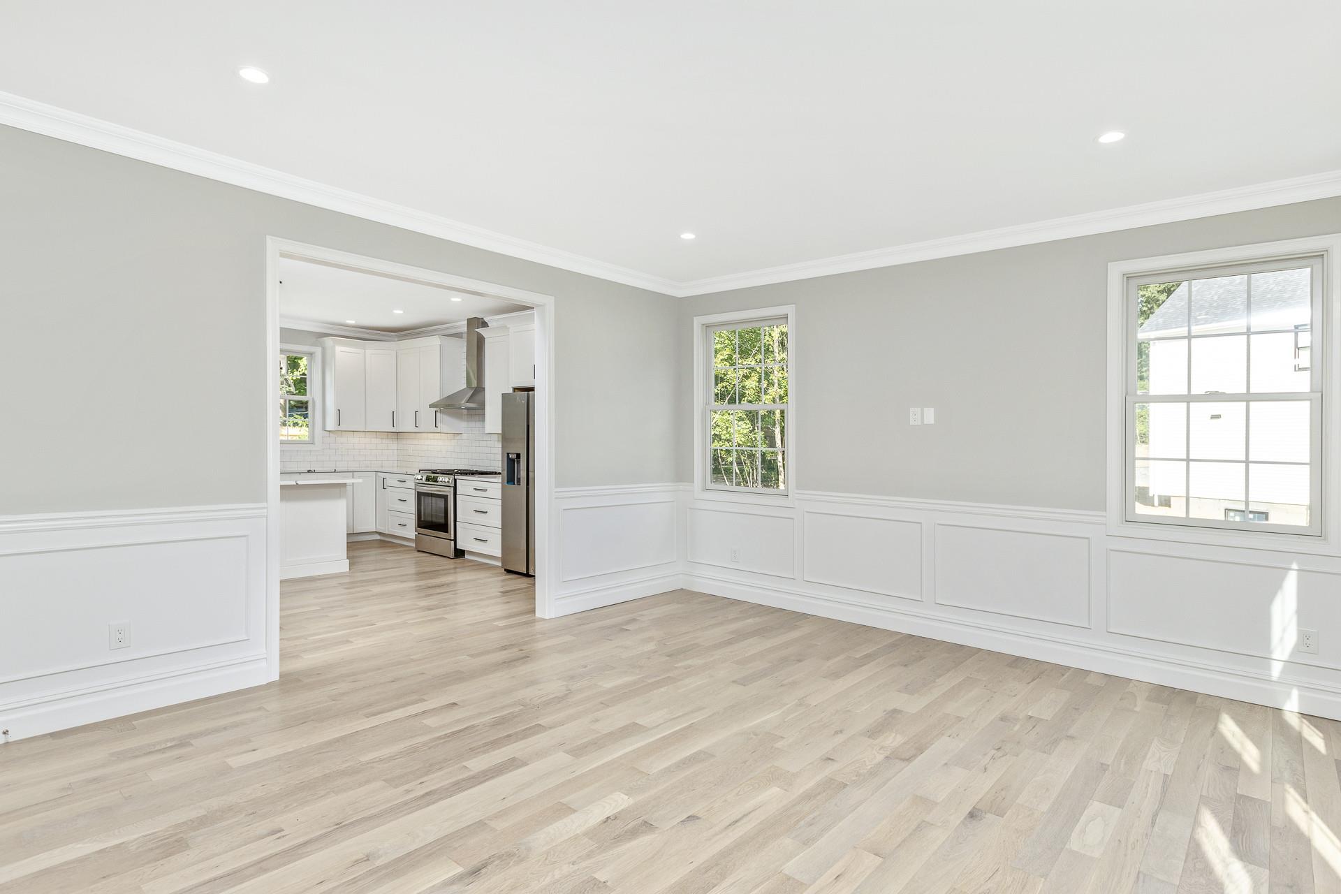 223 Town Line Road Commack, NY 11731 - Photo 4 of 32 an empty room with wooden floor and windows