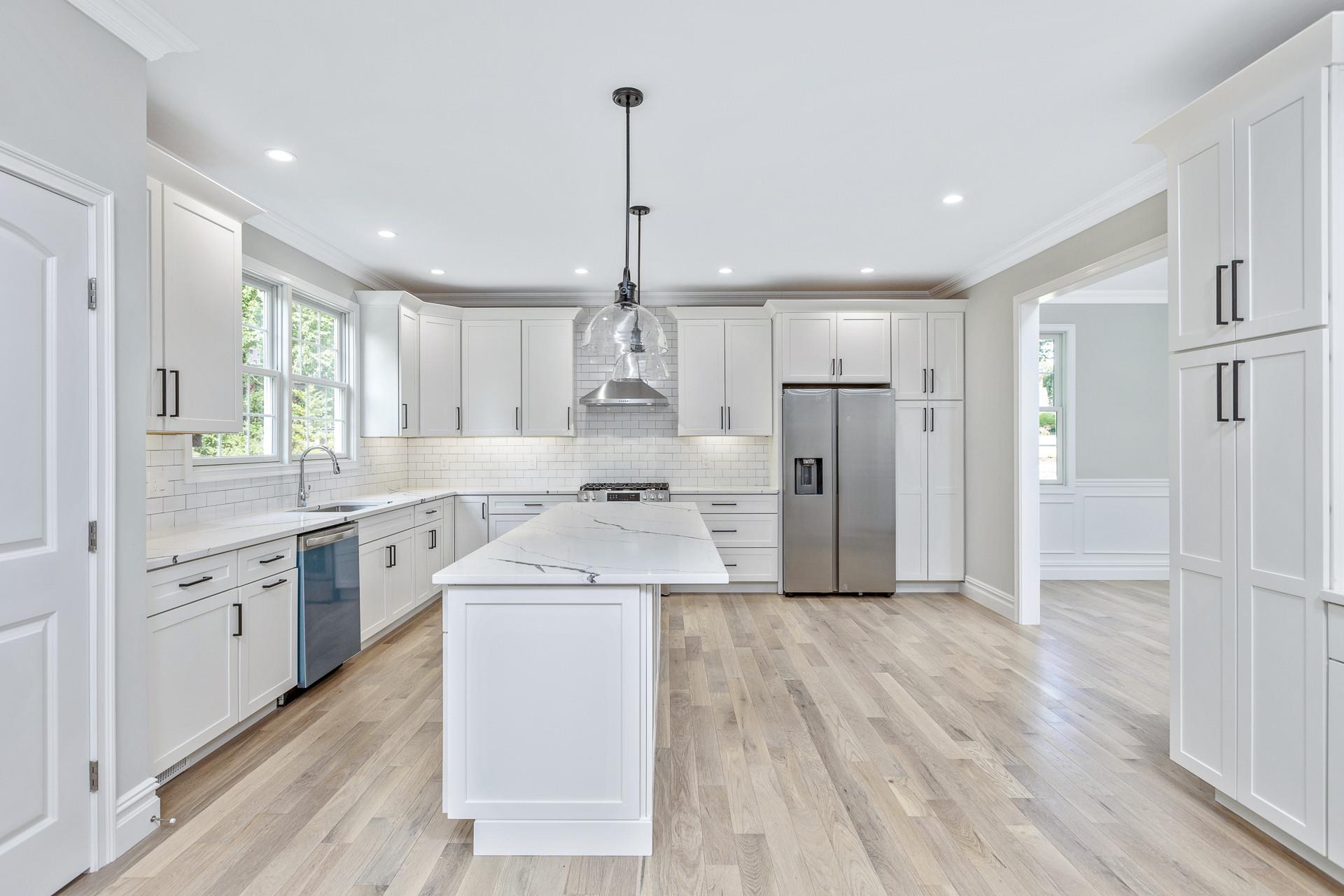 223 Town Line Road Commack, NY 11731 - Photo 9 of 32 a large kitchen with cabinets wooden floor and stainless steel appliances