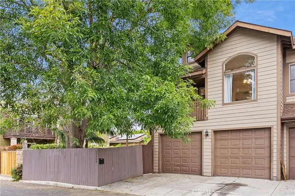 a front view of a house with a tree