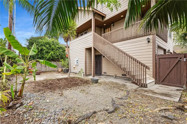 a view of a house with a yard and floor to ceiling window and palm tree