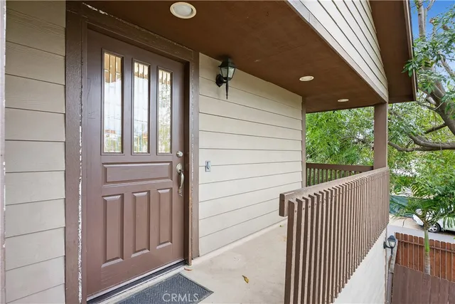 a balcony of a house with wooden floor outdoor seating and stairs