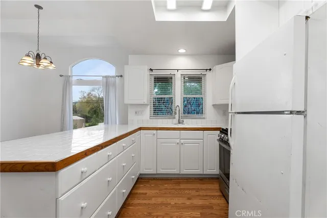 a kitchen with granite countertop a sink stove and refrigerator