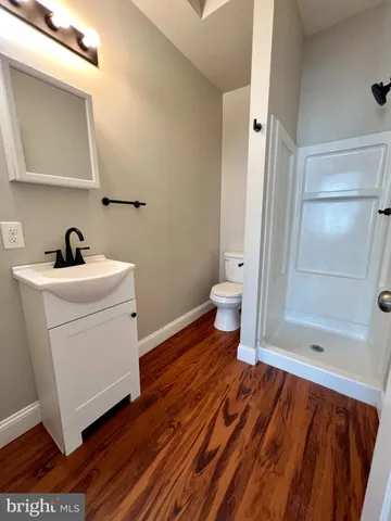 a bathroom with a sink a toilet and shower