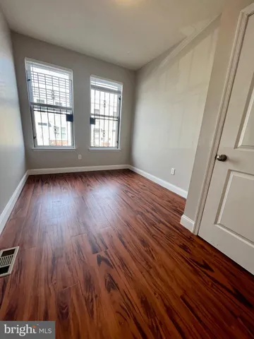 wooden floor in an empty room with a window
