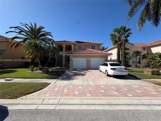a palm tree sitting in front of a house with a yard