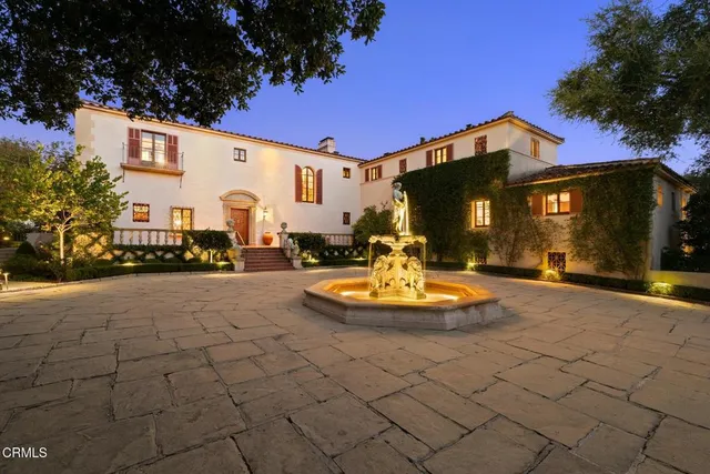 a view of a white house with a yard fire pit and outdoor seating