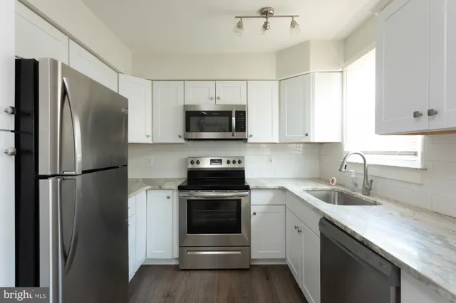 a kitchen with a sink a refrigerator a microwave and cabinets