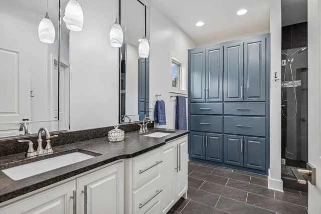 a bathroom with a granite countertop sink a vanity and a shower