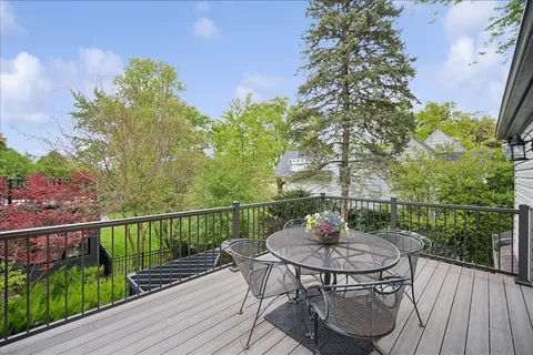 a balcony with wooden floor table and chairs