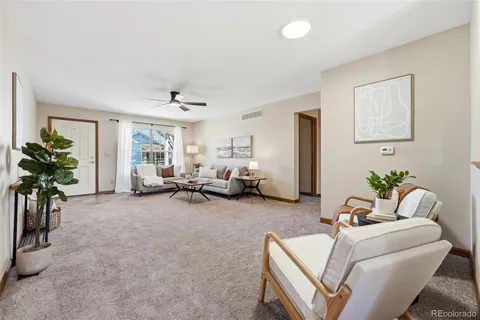 a living room with furniture and a potted plant