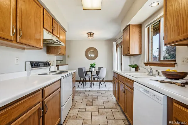 a kitchen with stainless steel appliances granite countertop a sink a stove counter space and cabinets