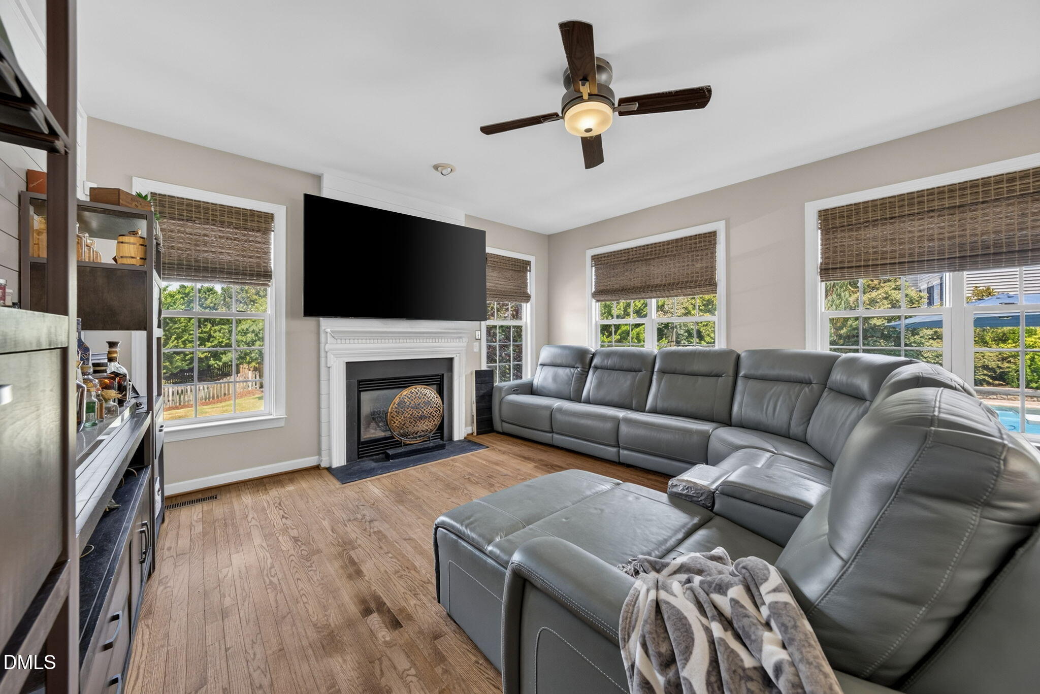 1258 Horsham Way Apex, NC 27502 - Photo 17 of 32 a living room with furniture a flat screen tv and a fireplace