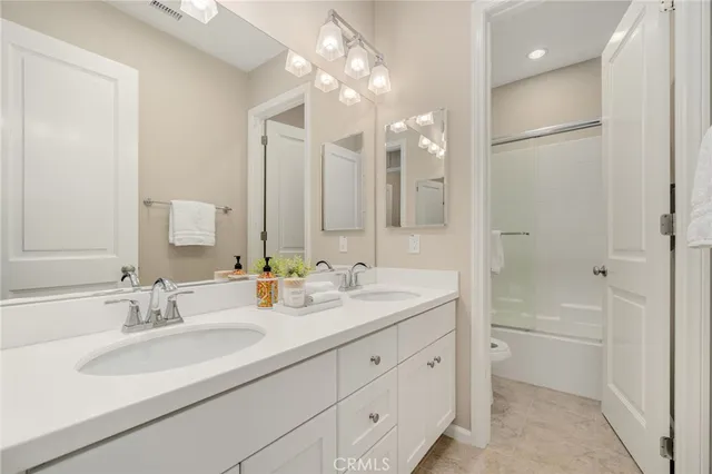 a bathroom with double vanity sinks and a mirror