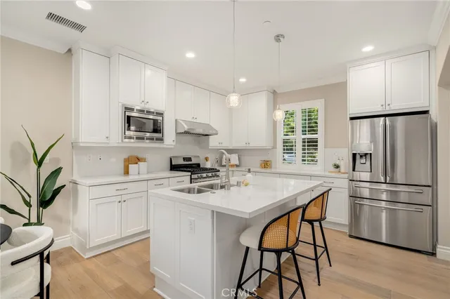 a kitchen with appliances a sink cabinets and a refrigerator