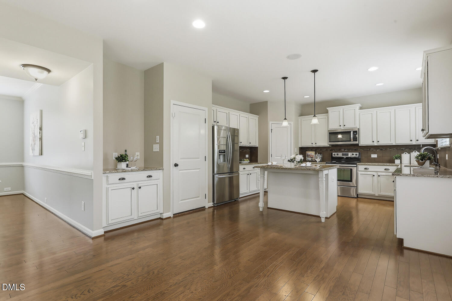 441 Virginia Water Drive Rolesville, NC 27571 - Photo 3 of 20 a kitchen with stainless steel appliances white cabinets and wooden floor