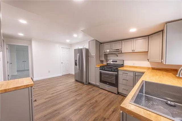 a kitchen with wooden floors and stainless steel appliances