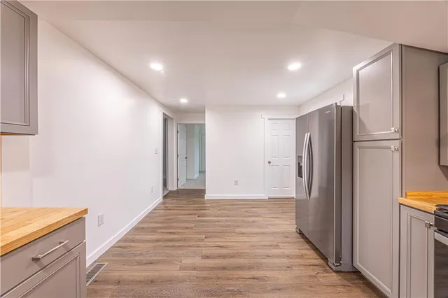 a view of a kitchen with a refrigerator and a stove top oven