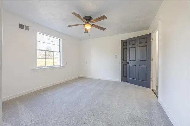 an empty room with closet and windows