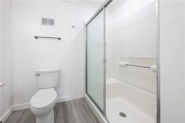 a bathroom with a toilet and a shower