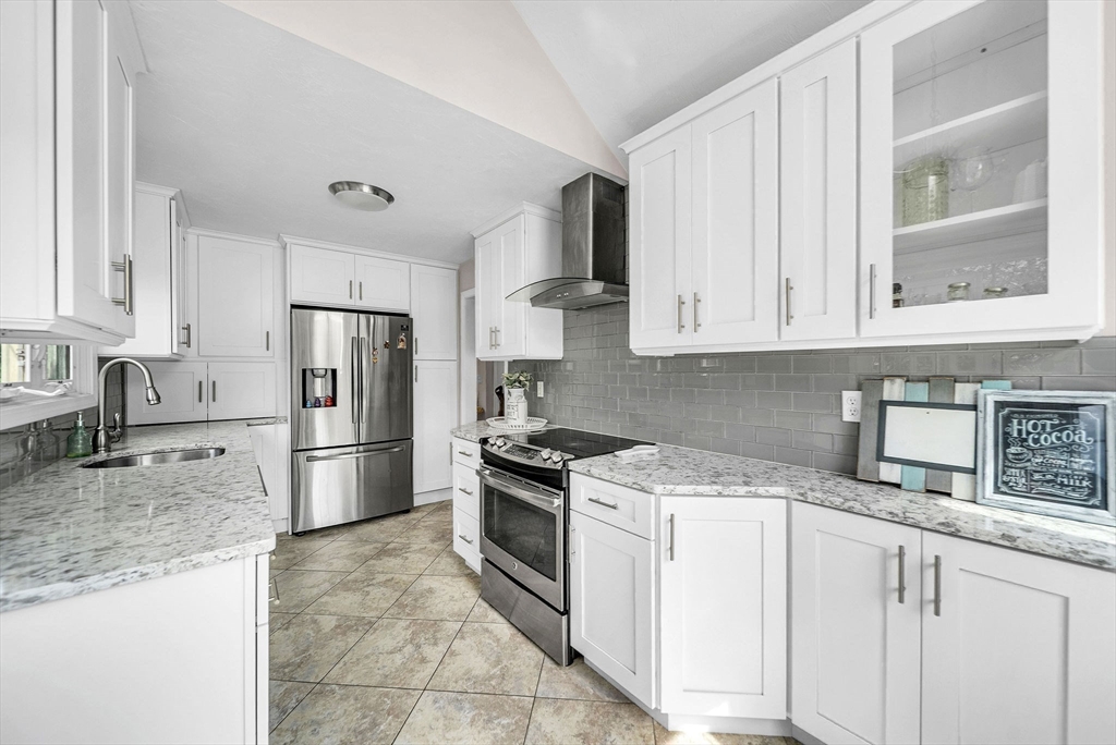 5 Weybridge Lane, Unit 5 Hopkinton, MA 01748 - Photo 11 of 34 a kitchen with stainless steel appliances granite countertop a stove a refrigerator and a white cabinets