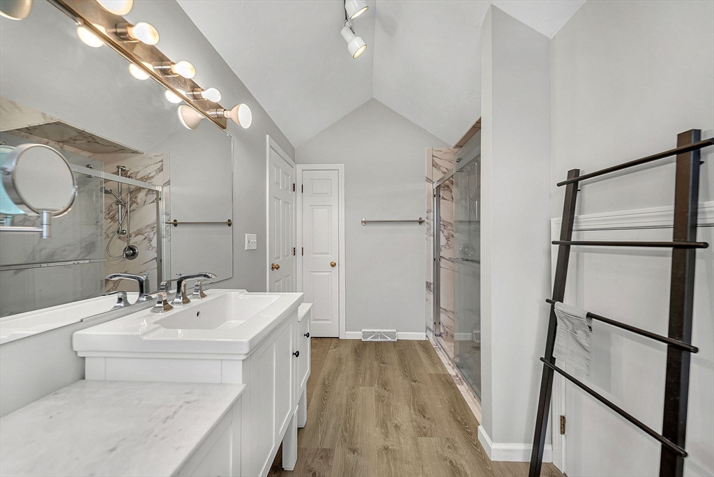 5 Weybridge Lane, Unit 5 Hopkinton, MA 01748 - Photo 23 of 34 a bathroom with a sink a mirror and a shower