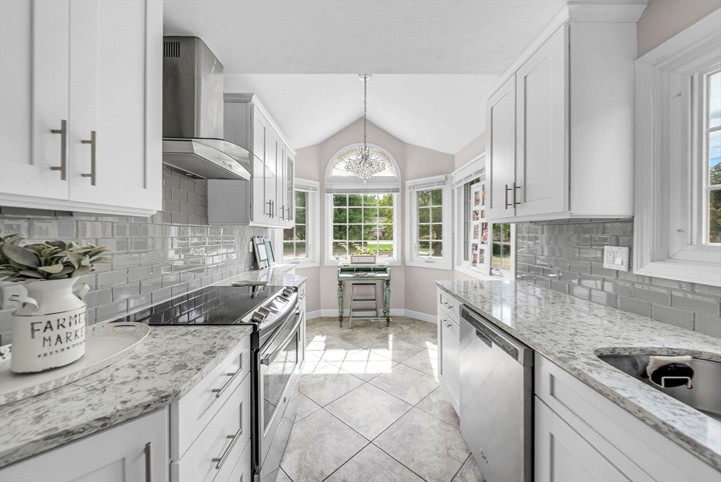 5 Weybridge Lane, Unit 5 Hopkinton, MA 01748 - Photo 8 of 34 a kitchen with granite countertop a sink a counter top space cabinets and stainless steel appliances