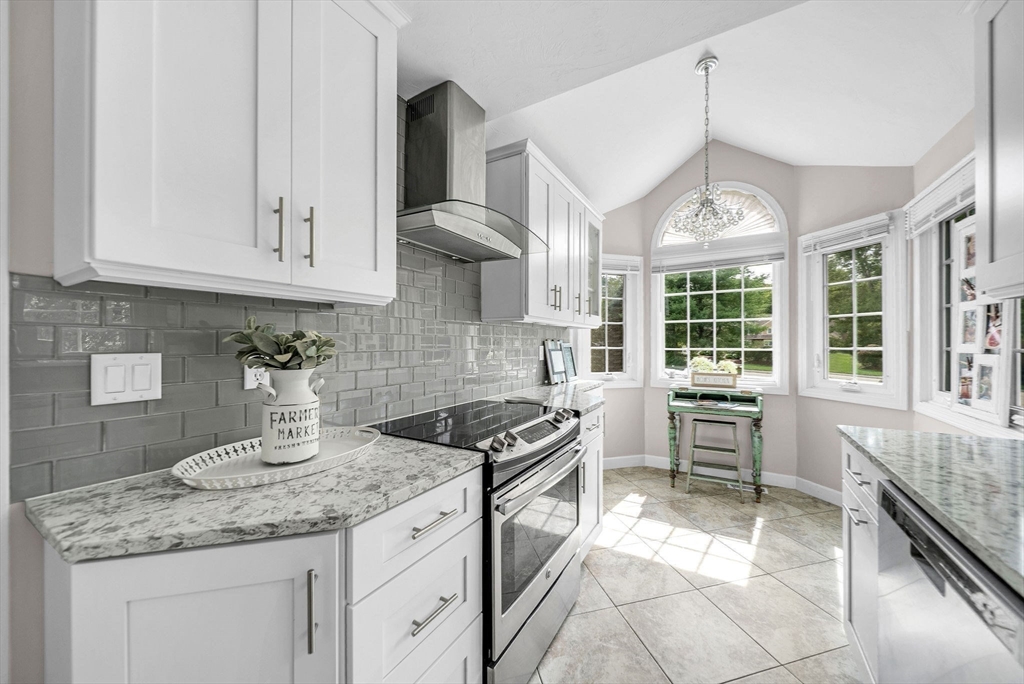 5 Weybridge Lane, Unit 5 Hopkinton, MA 01748 - Photo 10 of 34 a kitchen with granite countertop a sink stove and cabinets