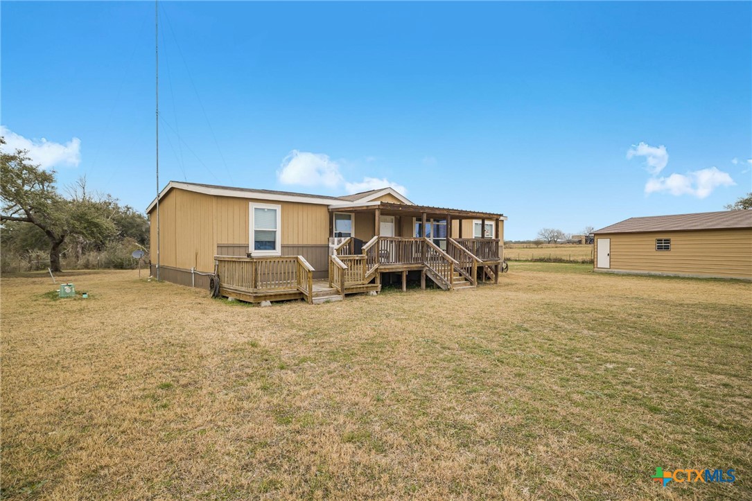 2610 Wendel Road Meyersville, TX 77974 - Photo 23 of 29 a view of a patio with table and chairs under an umbrella next to yard