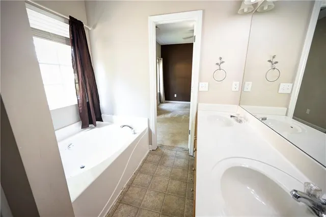a en suite bathroom with a tub sink and mirror