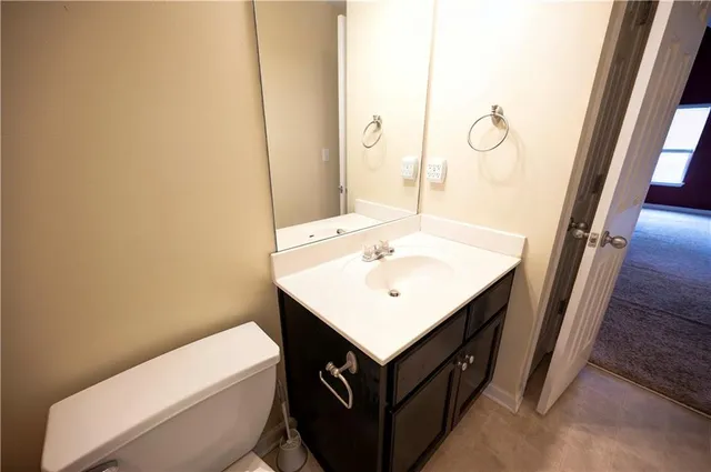 a bathroom with a sink a toilet and a mirror