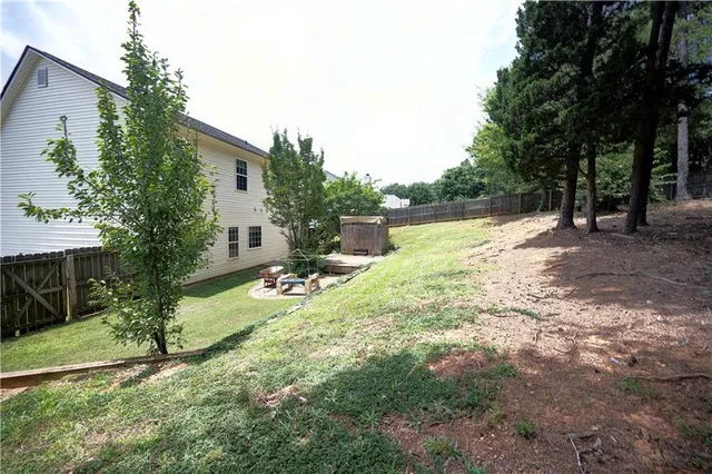 a view of a house with backyard and a tree