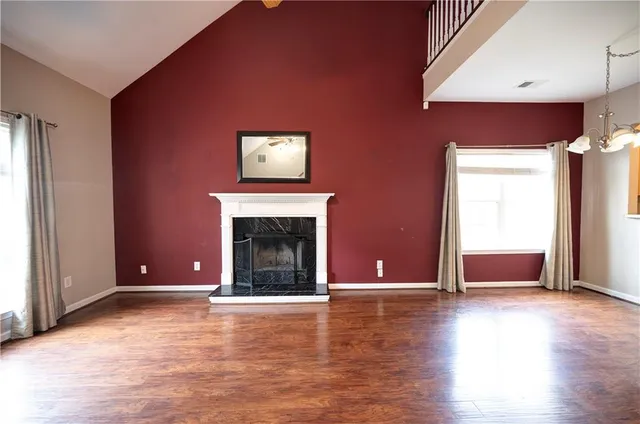 a view of a livingroom with wooden floor and a fireplace