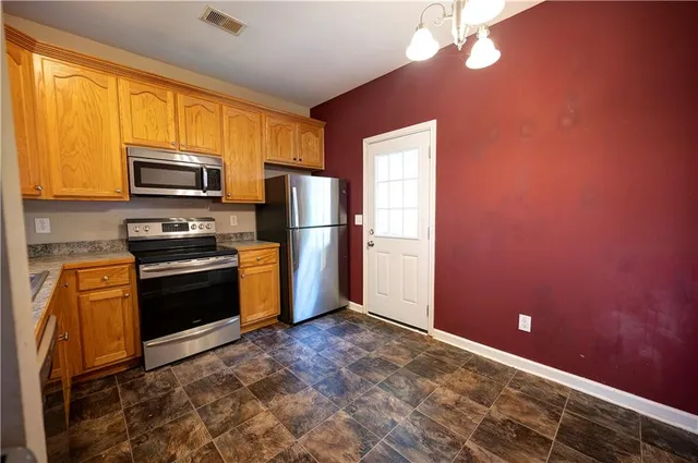 a kitchen with granite countertop stainless steel appliances and wooden cabinets