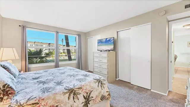 a bedroom with a bed and a large window