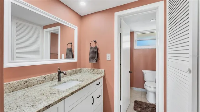 a bathroom with a granite countertop sink and a mirror